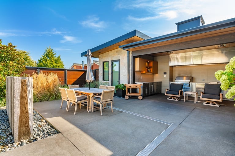 Exterior photograph of a mountain modern home residence with an expansive ocean front deck and swimming pool.