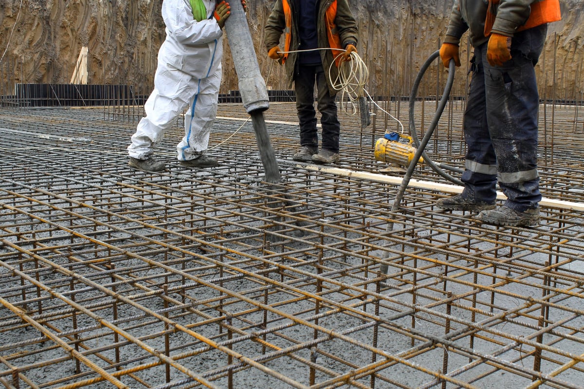 Pouring concrete into the reinforcement frame of the foundation slab made of reinforcement.